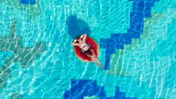 Mulher descansa em uma piscina, flutuando em um anel de borracha . — Vídeo de Stock