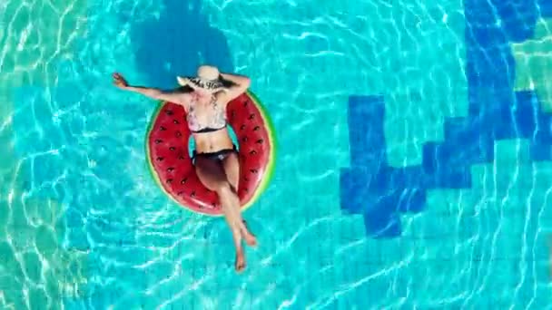 Отдыхающая женщина в купальнике плавает на резиновом кольце в бассейне . — стоковое видео