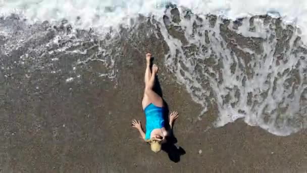 Girl lying on a beach in water, sunbathing. — Stock Video