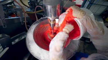 Kırmızı macun bir döner makineye konuyor.