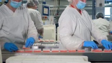 Yengeç çubukları kadın fabrika işçileri tarafından konveyörden çıkarılıyor..