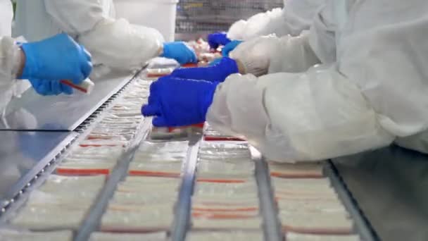 Manuelles Verpacken von Snacksticks in Plastikteller — Stockvideo