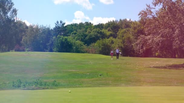 Les gens marchent sur un terrain de golf, parlant . — Video