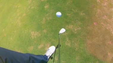 Bir kişi bir metal kulübü ile golf topu hokkabazlık.