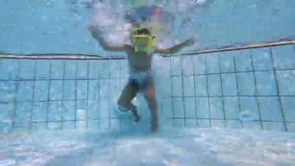 Filmagem subaquática de uma criança mergulhando na piscina — Vídeo de Stock