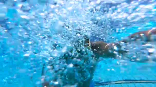 Sorrindo homem está atirando em si mesmo enquanto mergulhando na piscina — Vídeo de Stock