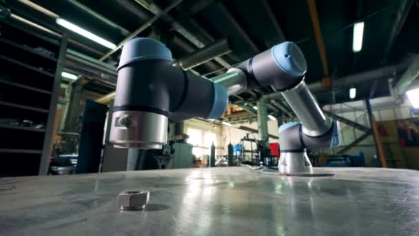 O braço robótico metálico trabalha com uma engrenagem em uma mesa . — Vídeo de Stock
