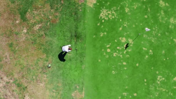 Una persona juega al golf en un campo verde, golpeando una pelota . — Vídeos de Stock