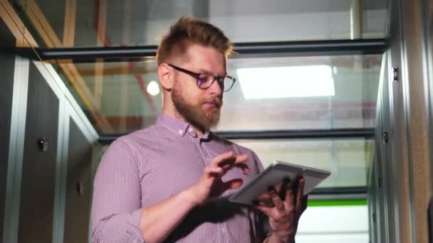 Bearded man met een Tablet in een server kamer — Stockvideo