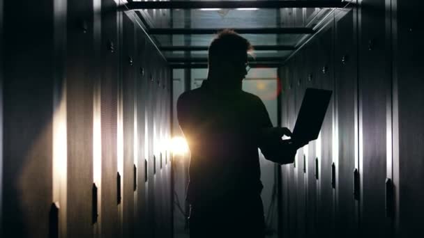 Kamer met servers en een silhouet van een mannelijke computer ingenieur — Stockvideo