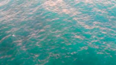 Günbatımı arka planında mavi deniz.