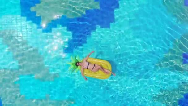 Ein Mädchen liegt auf einer Gummimatratze in einem Pool. Meer Luxus Urlaub Konzept. — Stockvideo