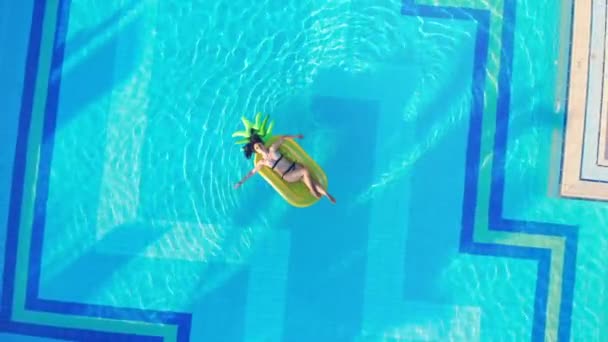 Koncepcja podróży letniej. Młoda kobieta relaksuje na żółtym materacu, pływające w basenie. — Wideo stockowe