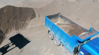 Çakıl traktör tarafından kamyon ların gövdesine basılıyor.