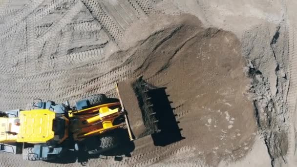 Un véhicule industriel déplace du gravier fissuré — Video