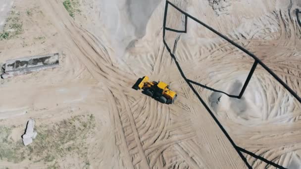 Site industriel avec un tracteur roulant le long d'elle dans une vue de dessus. Matériel minier à la carrière 