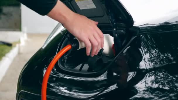 Black cars hood with an electrical nozzle during recharge — Stock Video