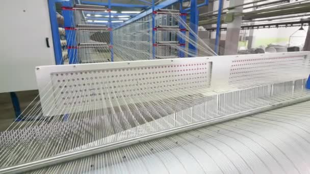 Snaren van witte draden worden snel verplaatst. Textielfabriek apparatuur. — Stockvideo