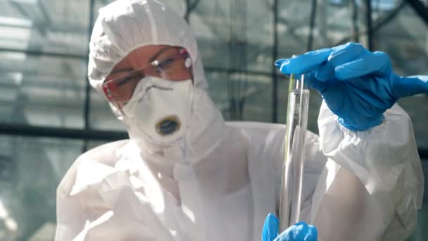 Жінка-біолог аналізує хімічну пробірку — стокове відео