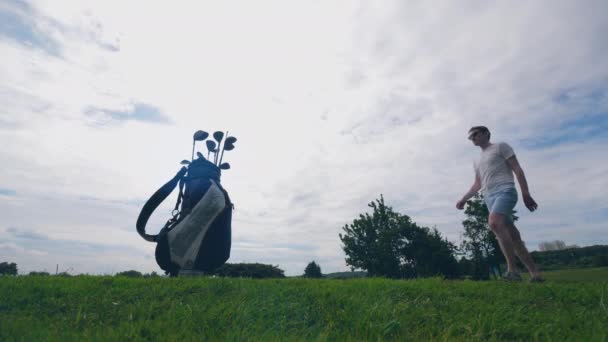 Mężczyzna gracz wybiera klub golfowy i się do niego wykorzystać — Wideo stockowe