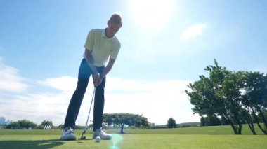Bir adam golf oynarken gol atıyor.