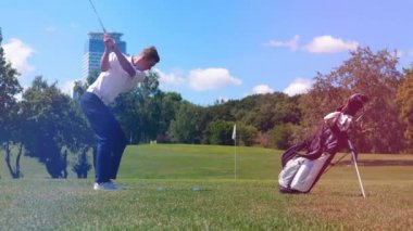 Erkek oyuncu gücü ile golf topu vuruyor