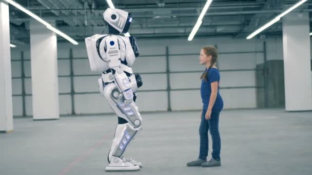 Un droid și o fată atingând mâinile, vedere laterală . — Videoclip de stoc