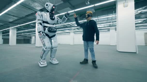 Ragazzo in VR occhiali muove le mani con un droide, da vicino . — Video Stock