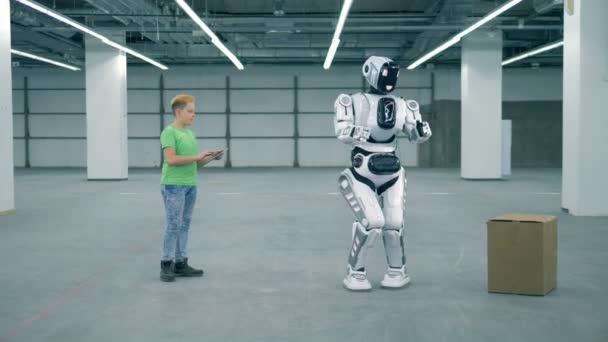 Uczeń używa tabletu, aby robot podnieść pudełko, z bliska. Koncepcja kształcenia w szkole podstawowej. — Wideo stockowe