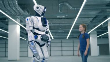 Bir robot ve bir kız el değdiren, yan görüş. Okul çocuğu, eğitim, fen sınıfı kavramı.