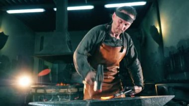 Demirci ısıtılmış metal bir bıçak çekiç