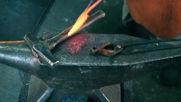 Instrumento de metal calentado se deja con un martillo en el yunque — Vídeos de Stock