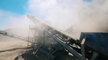 Çalışan konveyör bir taş ocağında moloz taşır.