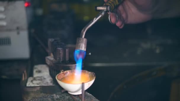 A burner is directed into a tiny jewelry plate. Jeweler Working jewelry — Stock Video