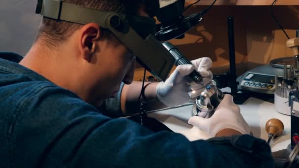 Goldsmith bearbetar en ring med en juvel. Juvelerare arbetar smycken — Stockvideo