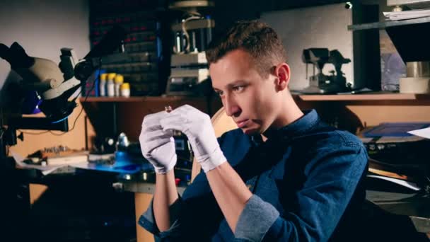 Joven artesano está observando un anillo con una piedra preciosa. El platero macho está quemando el marco del anillo de plata. Joyero hace una pieza de joyería — Vídeos de Stock