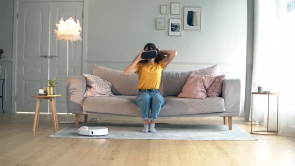 Жінка одягає VR-окуляри в кімнаті з робототехнічним конюшиною — стокове відео
