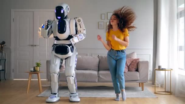 Sala de estar con una dama y un robot bailando alegremente — Vídeo de stock