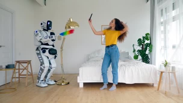 Human-like robot is cleaning while a lady is enjoying herself — Stock Video