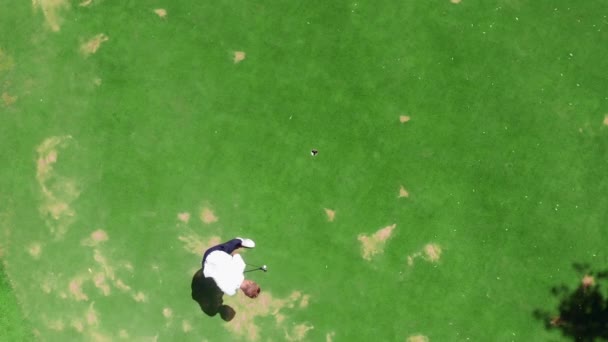 Vista desde arriba de un campo de golf con un hombre jugando el juego — Vídeo de stock