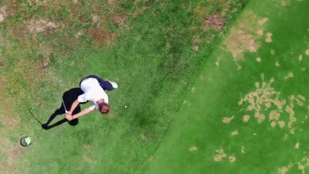 O homem está fortemente golpeando uma bola de golfe em uma vista superior — Vídeo de Stock