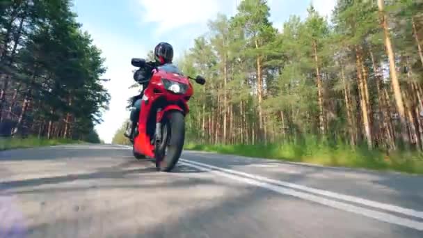 Camino del bosque con un hombre conduciendo una bicicleta. motociclista de carreras de su motocicleta . — Vídeos de Stock