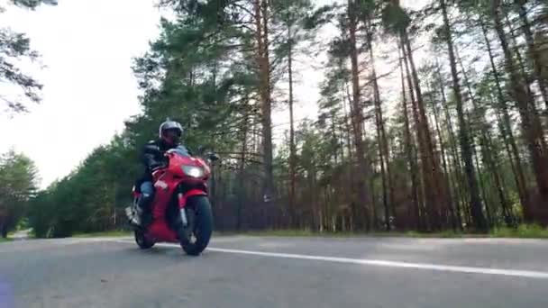 Fahrrad wird auf der Straße von einem Mann gefahren. Motorradfahrer rast mit seinem Motorrad. — Stockvideo