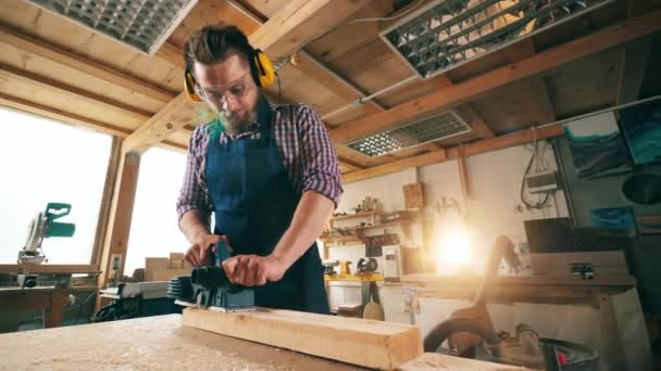 La madera está siendo aserrada por un carpintero masculino — Vídeos de Stock