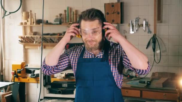 Menuisier en atelier de menuiserie. Un homme en tenue de travail sourit en étant à la menuiserie — Video