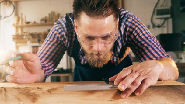 Řemeslník pečlivě měří dřevo — Stock video
