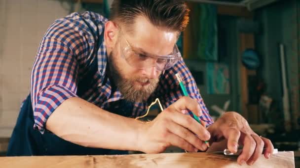 Handwerker, der in der Tischlerei arbeitet. Arbeiter misst Holz konzentriert — Stockvideo