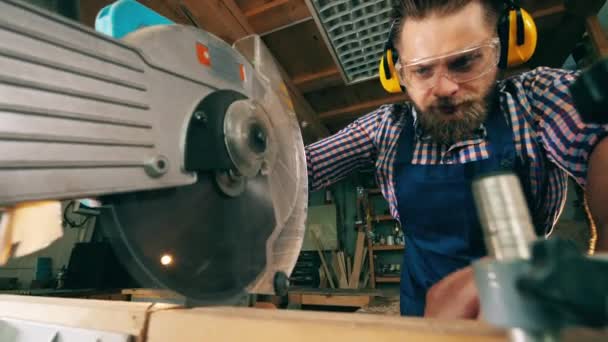 Řemeslník řeže dřevo kotoučovou pilou — Stock video