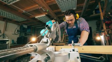 Erkek marangoz bir döner testere ile ahşap işleme