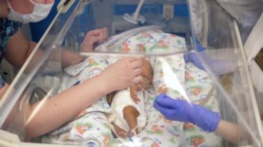 Hemşireler yeni doğmuş bir bebekle birlikte çalışır.